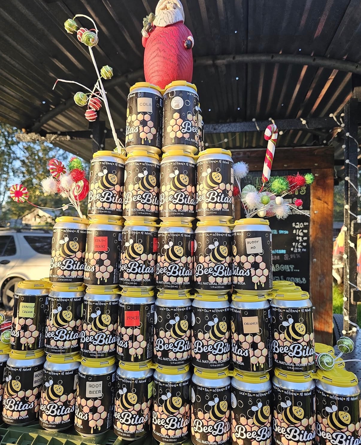 BeeBitas cans on a wooden crate at a farmers market